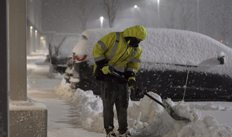 Worker shoveling snow by hand